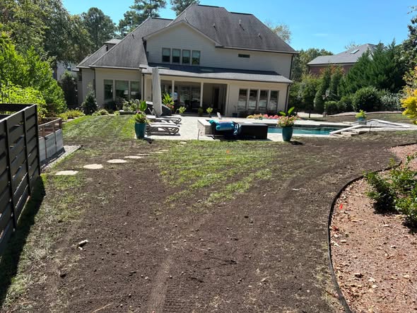 A lawn immediately after core aeration and compost topdressing, soil surface still visible in Willow Spring, NC.